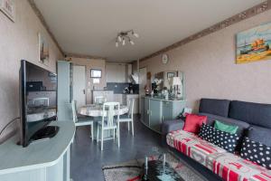 ein Wohnzimmer mit einem Sofa und einem Esszimmer in der Unterkunft L'Abri du Cap Horn - Proche plage pour 4 in Courseulles-sur-Mer