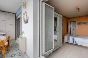 ein Schlafzimmer mit einem Bett und einem großen Fenster in der Unterkunft L'Abri du Cap Horn - Proche plage pour 4 in Courseulles-sur-Mer