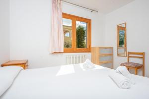 una camera con un letto bianco e una finestra di North House a Playa de Muro