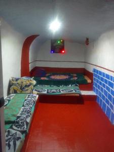 Habitación con 2 camas y TV en la pared. en CHEZ HASSANE BIKHIR, en Zaouia Sidi Ouaggag