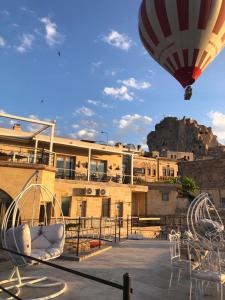 a hot air balloon flying over a building at Karlık Cave Suite Cappadocia in Uchisar