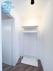 a white closet with a white shelf in a room at Basovizza 3 Alessandro Tirabora Short Rent in Villa Opicina