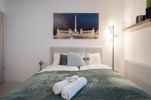 a bedroom with a bed with towels on it at Heroes Square Apartment in Budapest