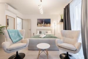 a bedroom with a bed and two chairs at Heroes Square Apartment in Budapest