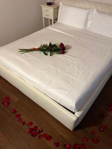 Una cama blanca con un arreglo floral. en Dimora 4 Spade, en Verona