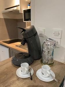 una macchinetta del caffè e due tazze su un bancone di La + belle chambre voûtée au cœur de Montpellier a Montpellier