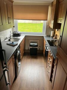 a small kitchen with a sink and a window at Geddes View in East Kilbride
