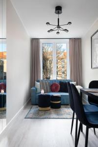 uma sala de estar com um sofá azul e uma mesa em Elite Apartments Garncarska Classy em Gdansk