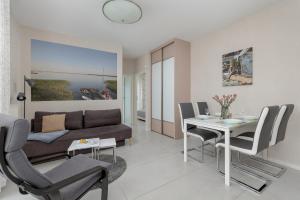 a living room with a couch and a table and chairs at Apartment MiAMar in Rogowo with Furnished Terrace and Parking by Renters in Rogowo