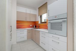 a white kitchen with white cabinets and a sink at Apartment MiAMar in Rogowo with Furnished Terrace and Parking by Renters in Rogowo