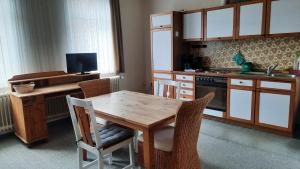 eine Küche mit einem Holztisch sowie einem Tisch und Stühlen in der Unterkunft Gemütliche Ferienwohnung mit Waldblick in Walsrode