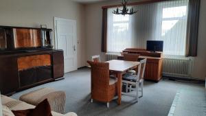 ein Wohnzimmer mit einem Holztisch und einem Schreibtisch in der Unterkunft Gemütliche Ferienwohnung mit Waldblick in Walsrode