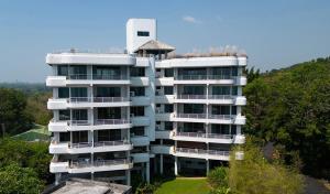 a tall white apartment building on top of a hill at TRIPLET Suite Rayong Seaview Private Beach in Ban Ko Kok