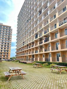 zwei Picknicktische vor einem großen Gebäude in der Unterkunft Saekyung Condominium in Lapu Lapu City