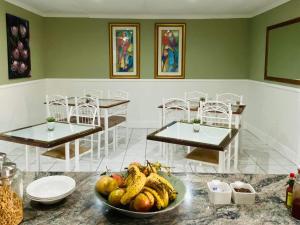 Karoo Country Guesthouse في De Aar: غرفة مع طاولتين ووعاء من الفواكه على طاولة