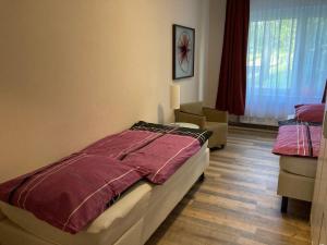 Schlafzimmer mit einem Bett mit einer roten Bettdecke in der Unterkunft Schulungszentrum Töplitz in Leest
