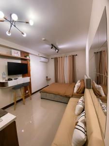 Schlafzimmer mit einem Bett, einem Schreibtisch und einem TV in der Unterkunft Saekyung Condominium in Lapu Lapu City