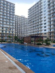 a large swimming pool in front of two large buildings at Saekyung Condominium in Lapu Lapu City