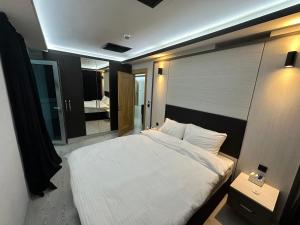 a bedroom with a large white bed and a mirror at KT SUİTE in Ankara