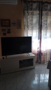 a living room with a flat screen tv on a cabinet at casa vacanza trastevere in Rome