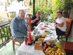 a group of people sitting around a table with food at Tam Coc Lotus Flower Homestay in Ninh Binh