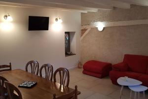 ein Wohnzimmer mit einem roten Sofa und einem Tisch in der Unterkunft Lolivia Gîte 8 personnes in Saint-Georges-sur-Cher