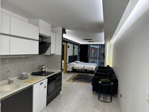 uma cozinha com um lavatório e uma sala de estar com uma cama em KT SUİTE em Ancara