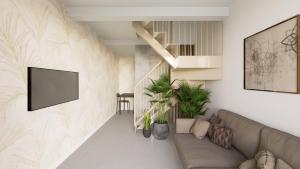 un soggiorno con un divano e una TV a parete di Style Madrid Center Santiago Bernabeu a Madrid