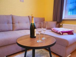 una botella de champán y dos copas de vino en una mesa en Ferienwohnung Wilde Bergwiese, en Benneckenstein