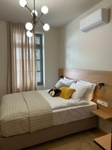 a bedroom with a bed with white sheets and a window at Living Yard Acropolis in Athens