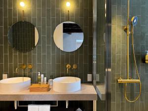 dois lavatórios numa casa de banho com dois espelhos em Portside Inn Hakodate em Hakodate