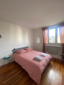 1 dormitorio con cama con sábanas rosas y ventana en Neuilly-sur-Seine calme et lumineux. B&B. 3 chambres en Neuilly-sur-Seine