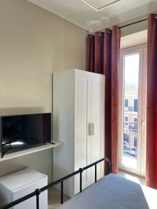 a bedroom with a bed and a cabinet with a tv at B&B Vittoria in Anzio