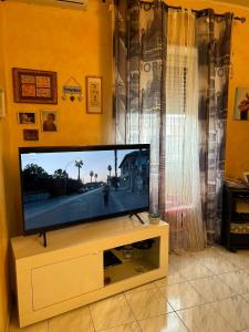 a flat screen tv sitting on a stand in a living room at casa vacanza trastevere in Rome