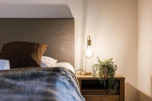 een slaapkamer met een bed en een tafel met een lamp bij Apartment Alios in Oostende