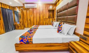 1 dormitorio con 1 cama grande y paredes de madera en FabHotel Prime Orion Crystal, en Calcuta