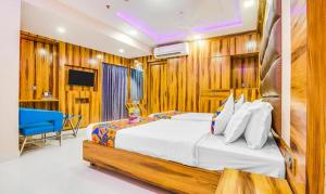 a bedroom with a bed with wooden walls and a tv at FabHotel Prime Orion Crystal in Kolkata