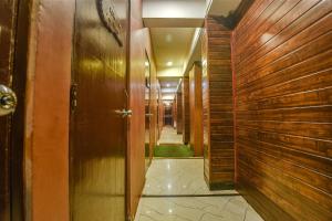 un pasillo con paredes de madera y un pasillo largo con puertas de madera en FabHotel Prime WS Beach Resort, en Goa