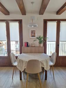 a dining room with a table and chairs and windows at Altxabi Apartamento Rural in Ochagavía