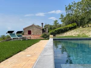 una piscina frente a una casa de piedra en Villa degli ulivi by Holiday World en Arqua Petrarca