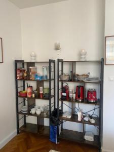 a shelf with cups and pots and pans at Neuilly-sur-Seine calme et lumineux. B&B. 3 chambres in Neuilly-sur-Seine