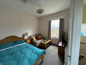 a bedroom with a bed and a couch and a television at The“LITTLE BOLT”In Reading. in Earley