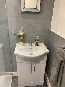 ein Badezimmer mit einem weißen Waschbecken und einem Spiegel in der Unterkunft Ouse House in Swinefleet