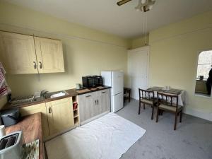 a kitchen with a table and a white refrigerator at The“LITTLE BOLT”In Reading. in Earley