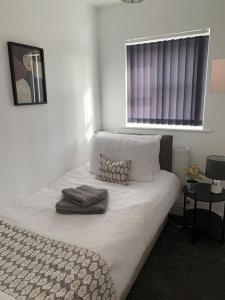 Schlafzimmer mit einem Bett mit weißer Bettwäsche und einem Fenster in der Unterkunft Ouse House in Swinefleet