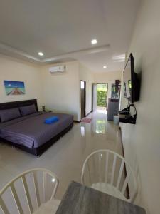 a bedroom with a bed and a table and chairs at Loma Beach Resort in Ban Pak Nam Pak Duat