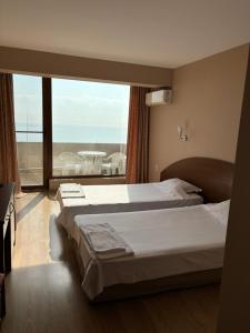 a bedroom with two beds and a large window at Relax Guest House in Burgas City