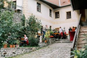 a group of people sitting at tables outside of a building at Appartements Adam-Mühle in Spitz