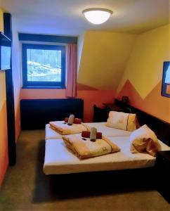 a hotel room with two beds with a window at Sporthotel Bohemia in Rokytnice nad Jizerou