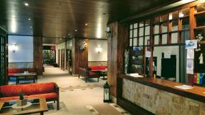 a lobby of a store with a red couch and tables at Sporthotel Bohemia in Rokytnice nad Jizerou